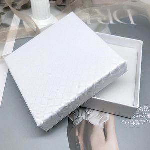 Close-up of a white jewelry gift box featuring elegant diamond quilted texture