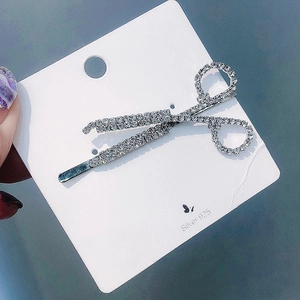 Detailed macro view of silver scissors hair clip with sparkling rhinestones decoration