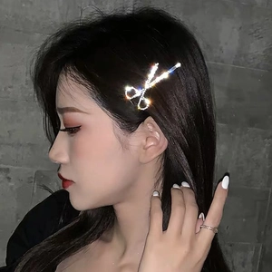 Sparkling silver scissors hair clip with crystals worn on model's side hair