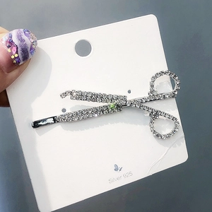 Detail of creative scissor-shaped hair clip with sparkling diamonds on S925 display card