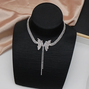 Dettaglio della collana con farfalla e nappe in cristallo su supporto in velluto