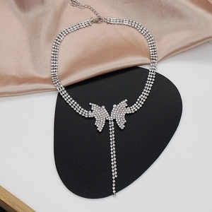 Dettaglio pendente a farfalla con choker di strass a tre file e nappa lunga