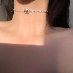 Primer plano de la elegante gargantilla de piedra rosa y pedrería brillante en el cuello