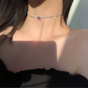 Detalle de un colgante de circón rosa brillante en un collar choker de diamantes imitación
