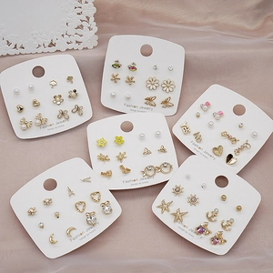 Detail of 925 silver needle stud earrings set with pearls and crystals on silk background