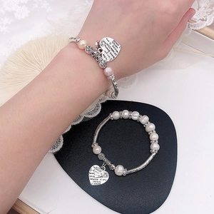 Details des elastischen Süßwasserperlenarmbands mit Herzanhänger und Rosen-Zwischenstücken