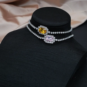Detalle de collares gargantilla de lujo con colgantes de cristal amarillo y rosa