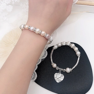 Detailansicht von Perlenarmbändern mit Herzanhängern und Kristall-Abstandshaltern