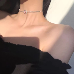 Detalle de gargantilla de plata con piedra rosa de corte princesa lucida por una modelo