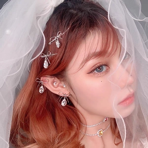 Detalle de conjunto de joyería nupcial con lazos de cristal y piedras amarillas
