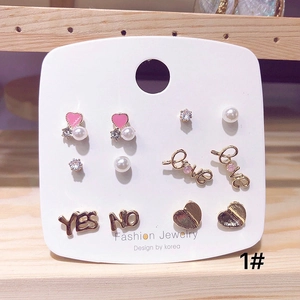 Close-up of 6-pair gold stud earring set with pink hearts and pearls on display card