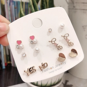 Detail of 925 silver needle stud earrings set with hearts, pearls and love letters