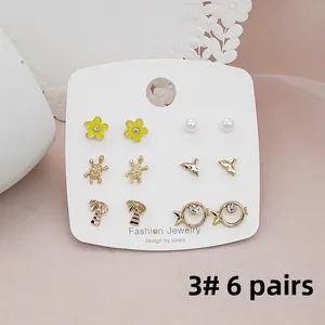 Detailed close-up of 6 pairs set earrings featuring floral and marine motifs on silk