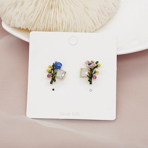 Detailed close-up of asymmetrical enamel flower earrings with Silver 925 needle on white card
