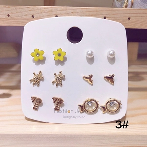 Detail of 925 silver needle earring set featuring gold turtles, pearls and ocean motifs