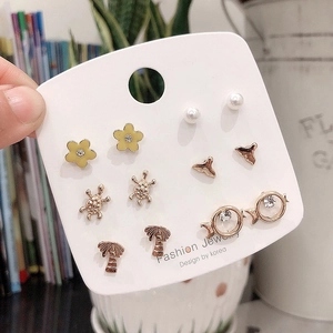 Detailed set of six pairs of gold earrings with pearls, flowers, and sea life motifs