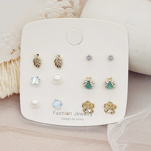 Macro shot of 925 silver needle earring set featuring zircon and pearl on card