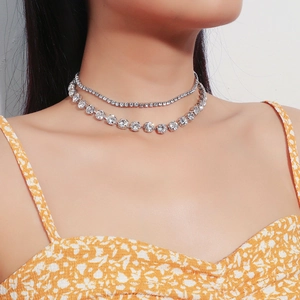 Detalle de un collar choker de doble capa con pedrería plateada puesto al cuello