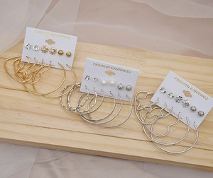 Detailed close-up of fashion earring sets with gold and silver hoops, studs, and pearls