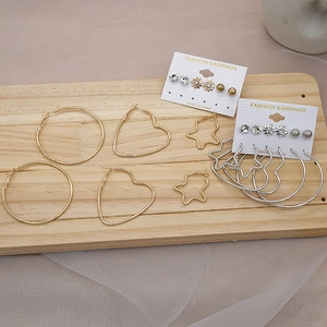 Detail of diverse hoop earring set with heart and star shapes on wooden display