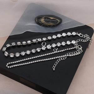 Detalle macro del collar tenis plateado y la fina cadena choker con cristales brillantes