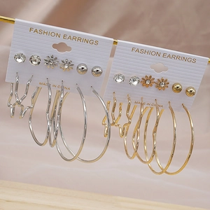 Detail view of 6-pair gold and silver earring set with C-shape hoops and daisy studs