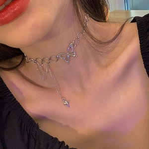 Silver butterfly choker with cross pendant and tassel chains on a woman neck