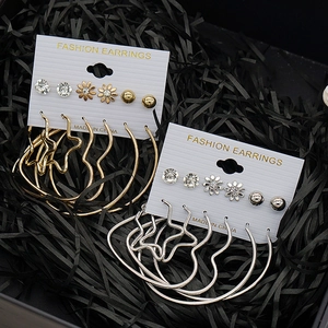 Fashion earring set featuring gold and silver C-shaped hoops and heart studs on a card