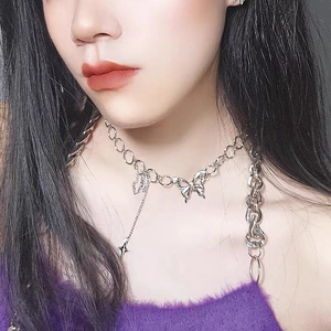 Close-up of silver butterfly pendant necklace with star chain detail on model