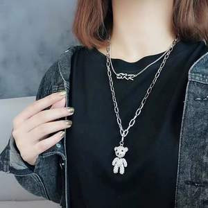 Détail d'un collier double épaisseur avec pendentif ours étincelant en strass