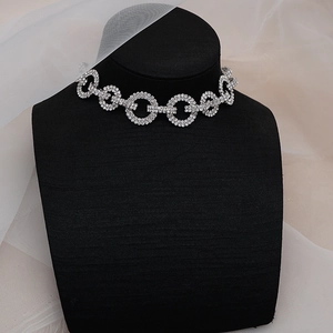 Primer plano del collar gargantilla de strass brillante en soporte para joyas