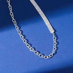 Primer plano detallado de un collar de cadena plateada con pedrería de varias filas y eslabones