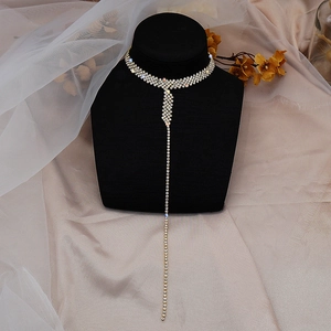 Elegant gold long tassel choker necklace with sparkling rhinestones on a black display