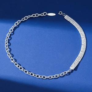 Elegante collar de cadena con pedrería plateada y diseño asimétrico sobre fondo azul