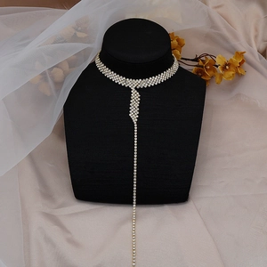 Detailed close-up of a silver rhinestone choker with long tassel on a black neck mannequin