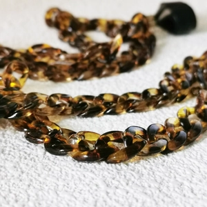 Macro detail of tortoiseshell acrylic chain links for anti-lost wireless earbuds strap