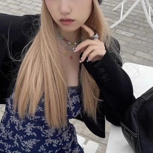 Détail de colliers de fleurs superposés et bague argentée sur un mannequin stylé