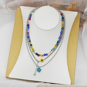 Détail d'un collier triple rang avec perles en verre millefiori et pendentifs de fleurs