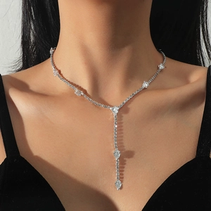 Detalle de circonitas en forma de pera en el collar en Y plateado con borlas finas