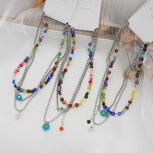 Gros plan du collier à perles Y2K avec pendentifs fleurs en résine colorés et chaînes en métal