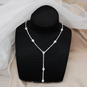 Detalle de collar en Y plateado con circonitas de gota en busto de terciopelo negro