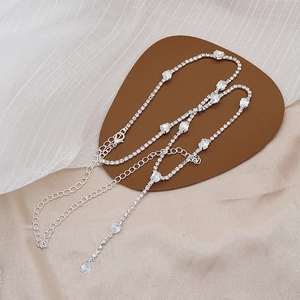 Detalle de collar plateado con circonitas en forma de gota y cierre de langosta ajustable
