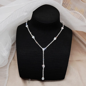 Elegante collar en Y plateado con circonitas brillantes en forma de gota en un maniquí