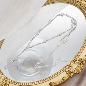Detalle de collar plateado con piedras redondas brillantes y cierre de langosta ajustable