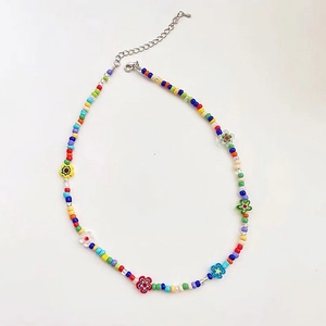 Detalle de collar de cuentas coloridas con detalles florales y cierre de langosta ajustable