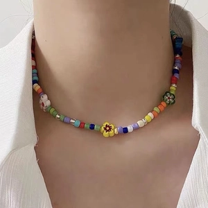 Primer plano de un collar de cuentas de colores con flores en modelo con detalles vivos