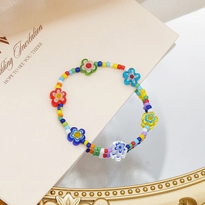 Detalle de un collar de cuentas de colores hecho a mano con flores de vidrio en bandeja
