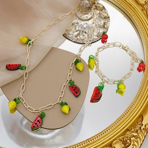 Ensemble collier et bracelet à grosse chaîne dorée avec breloques fruits colorés