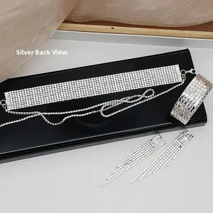Vista dettagliata del retro di girocollo, bracciale e orecchini con strass argentati