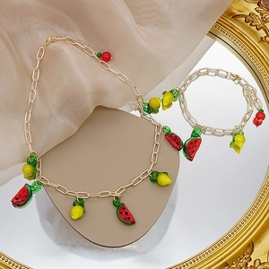Détail du lot de collier et bracelet en perles de fruits avec breloques pastèque et citron